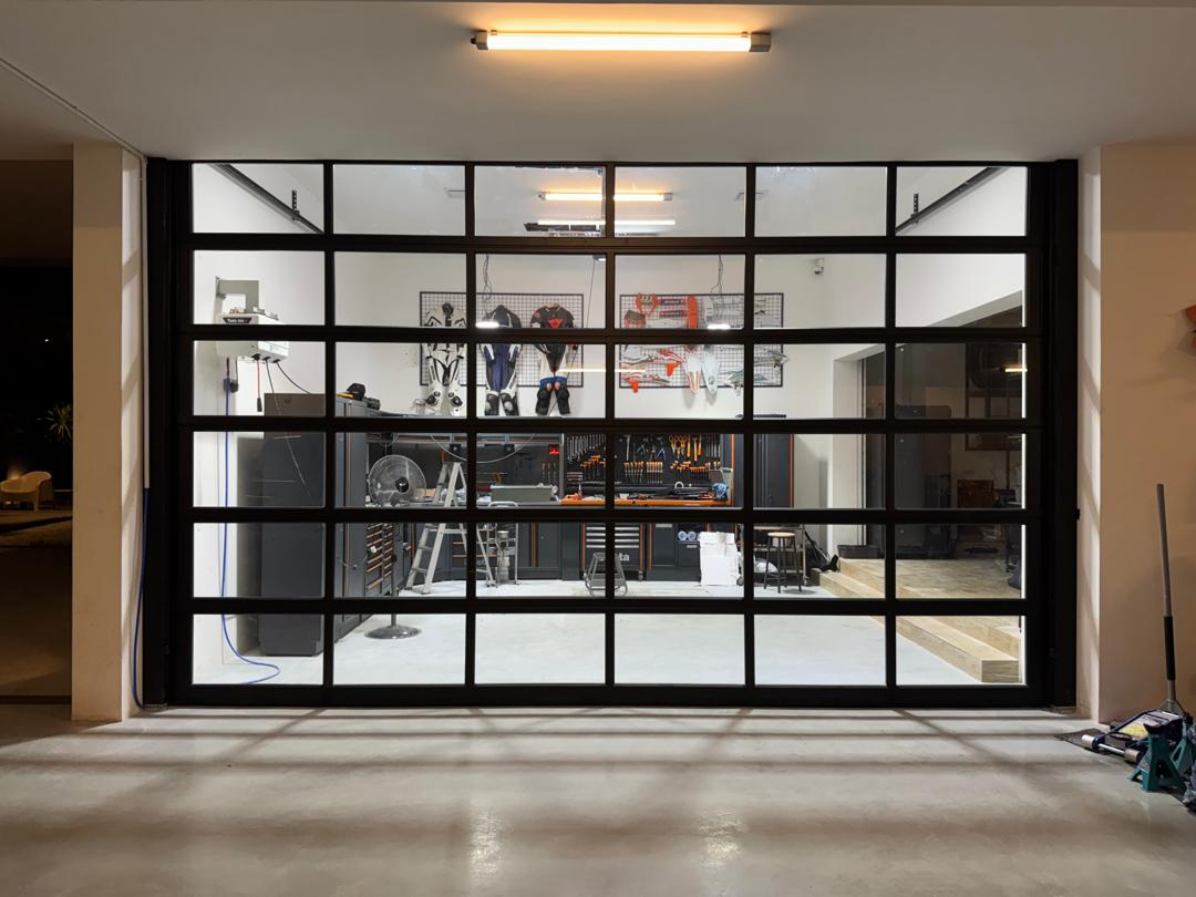 Full-view aluminum and glass sectional garage door installed at modern residential property Malaysia